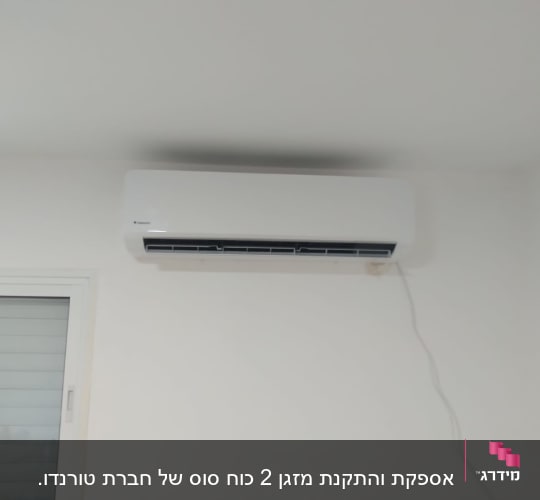 מזגן מותקן על קיר לבן עם כבל חשמל